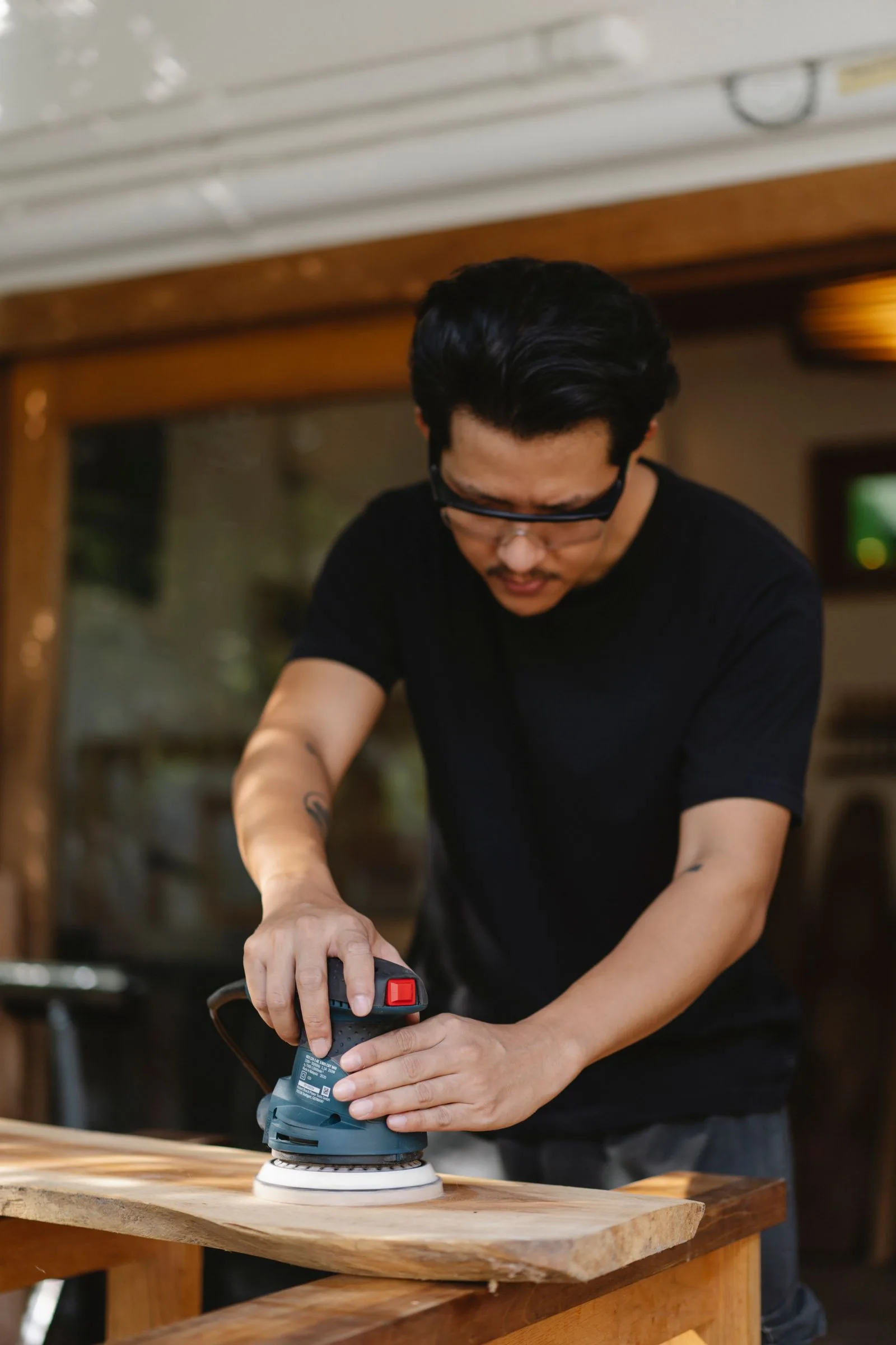 Handwerker schleift Holz mit dem Exzenterschleifer